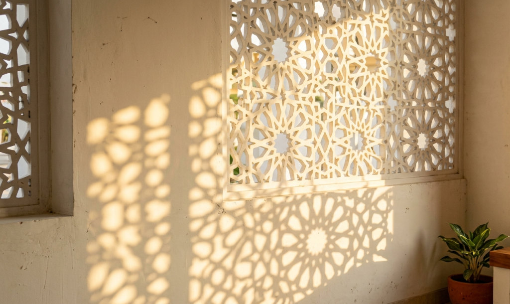 Permainan cahaya yang menembus pola krawangan menciptakan efek visual yang berubah sepanjang hari sesuai pergerakan matahari.